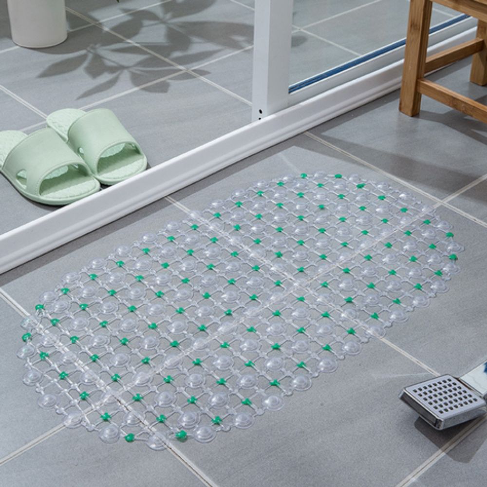 Clear bath mat with green dots on a bathroom floor