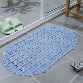 Blue textured bath mat on a tiled bathroom floor with green slides nearby.