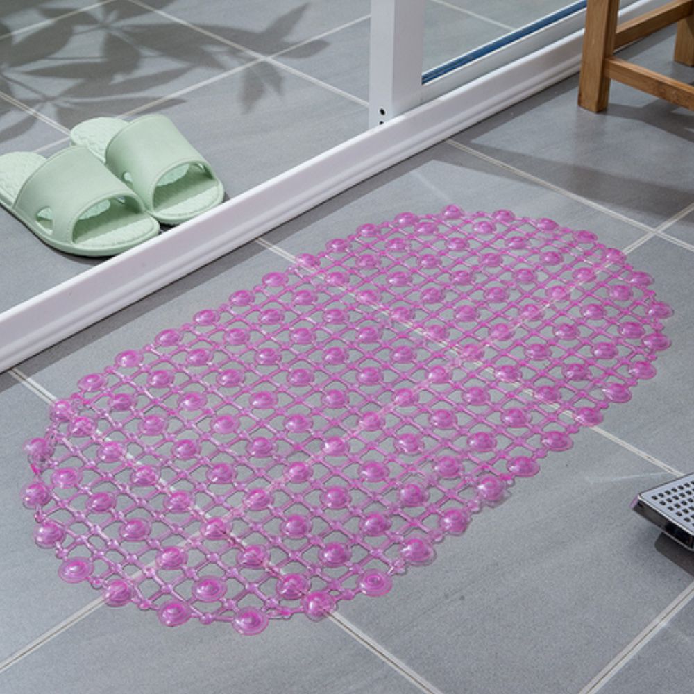 Pink bath mat on a tiled bathroom floor with green slides nearby.