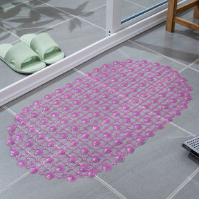 Pink bath mat on a tiled bathroom floor with green slides nearby.