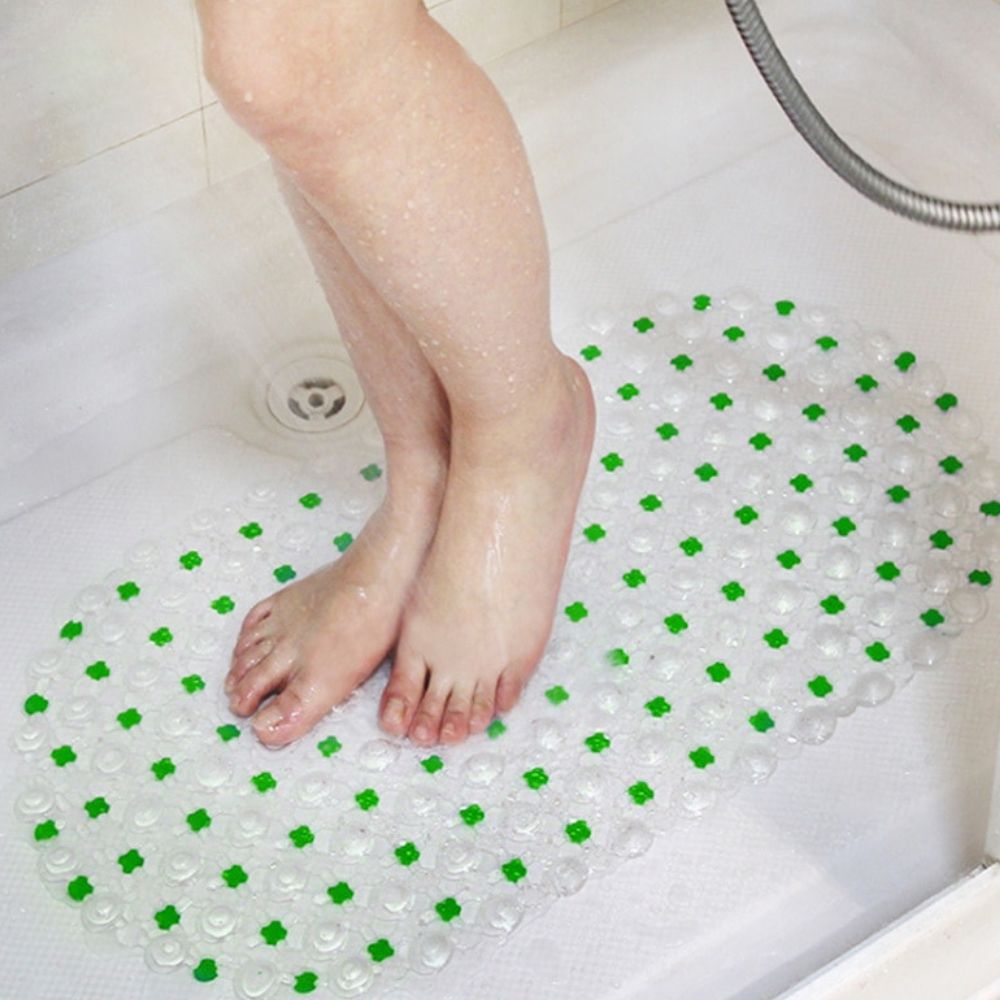 Child's feet on a green and clear bath mat in a bathtub