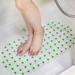 Child's feet on a green and clear bath mat in a bathtub