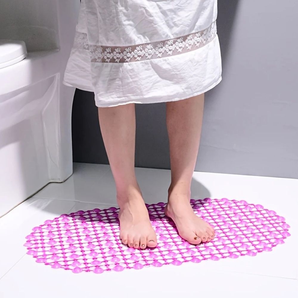 Person standing on a pink bath mat in a bathroom.