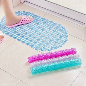 Blue and pink textured mats on a tiled floor with a person wearing pink sandals.