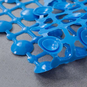 Close-up of a blue plastic mat with a grid pattern on a gray surface