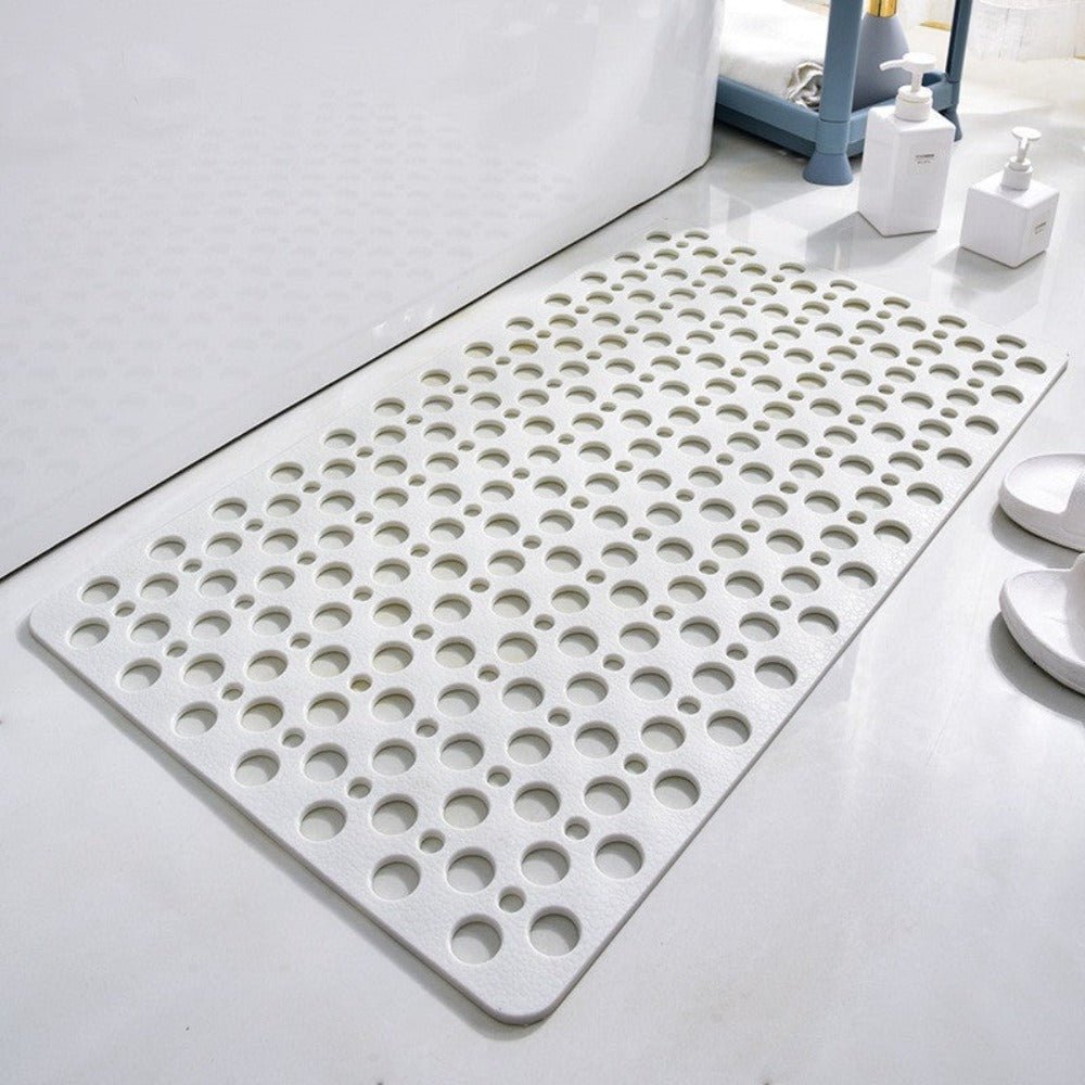 White bath mat with circular holes on a bathroom floor