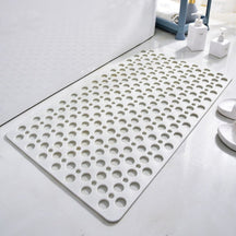 White bath mat with circular holes on a bathroom floor