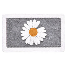 Gray bath mat with a white daisy design on a white background