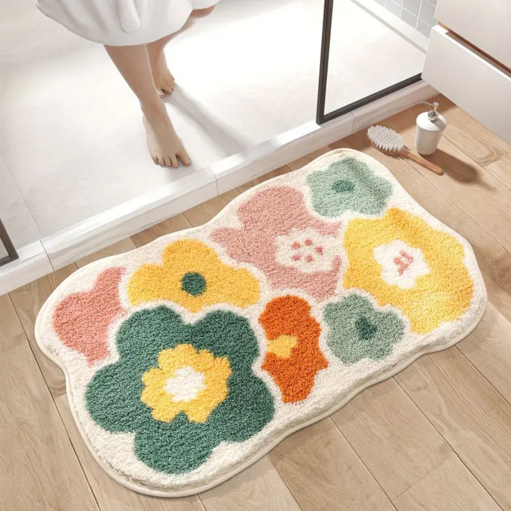 Floral patterned bath mat on a wooden floor with a bathroom setting.