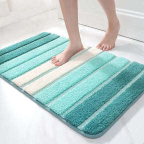Striped bath mat with gradient colors on a white floor.