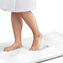 Person standing on a white mat with a white background