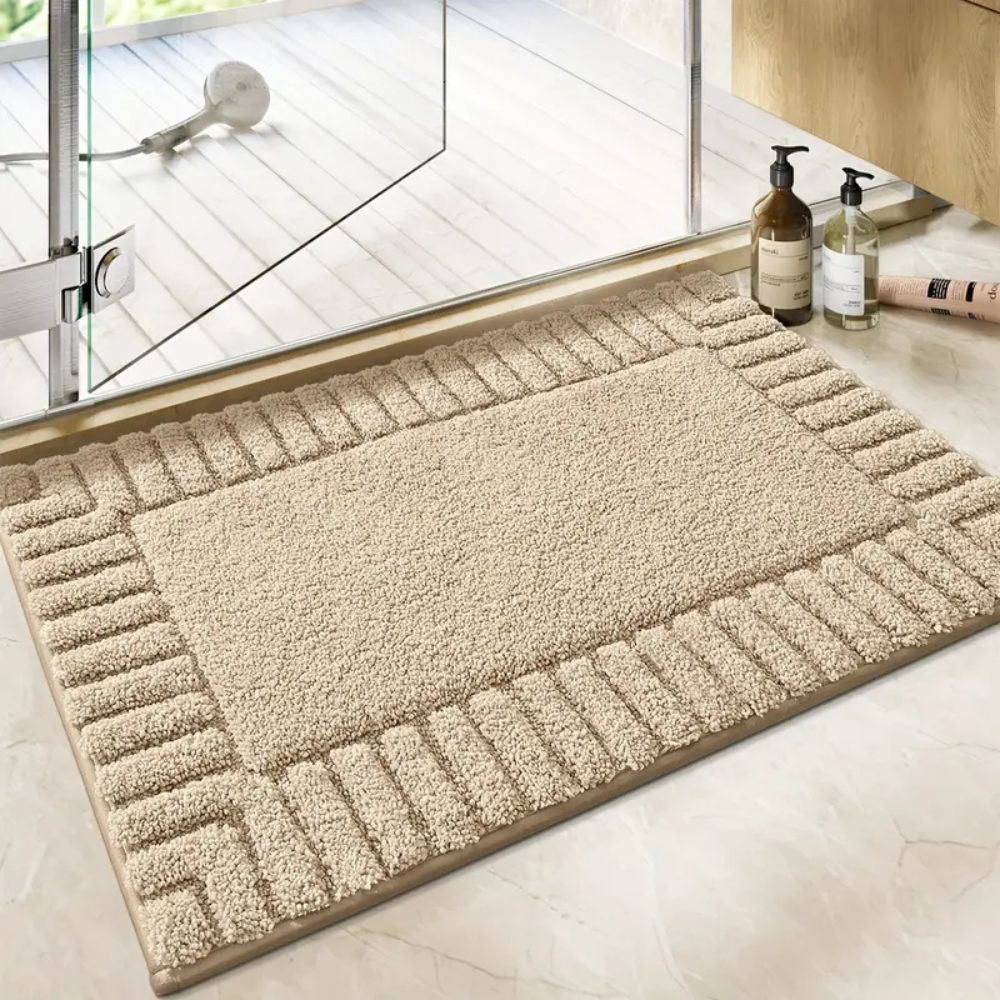 Beige doormat on a light wooden floor with a glass door in the background
