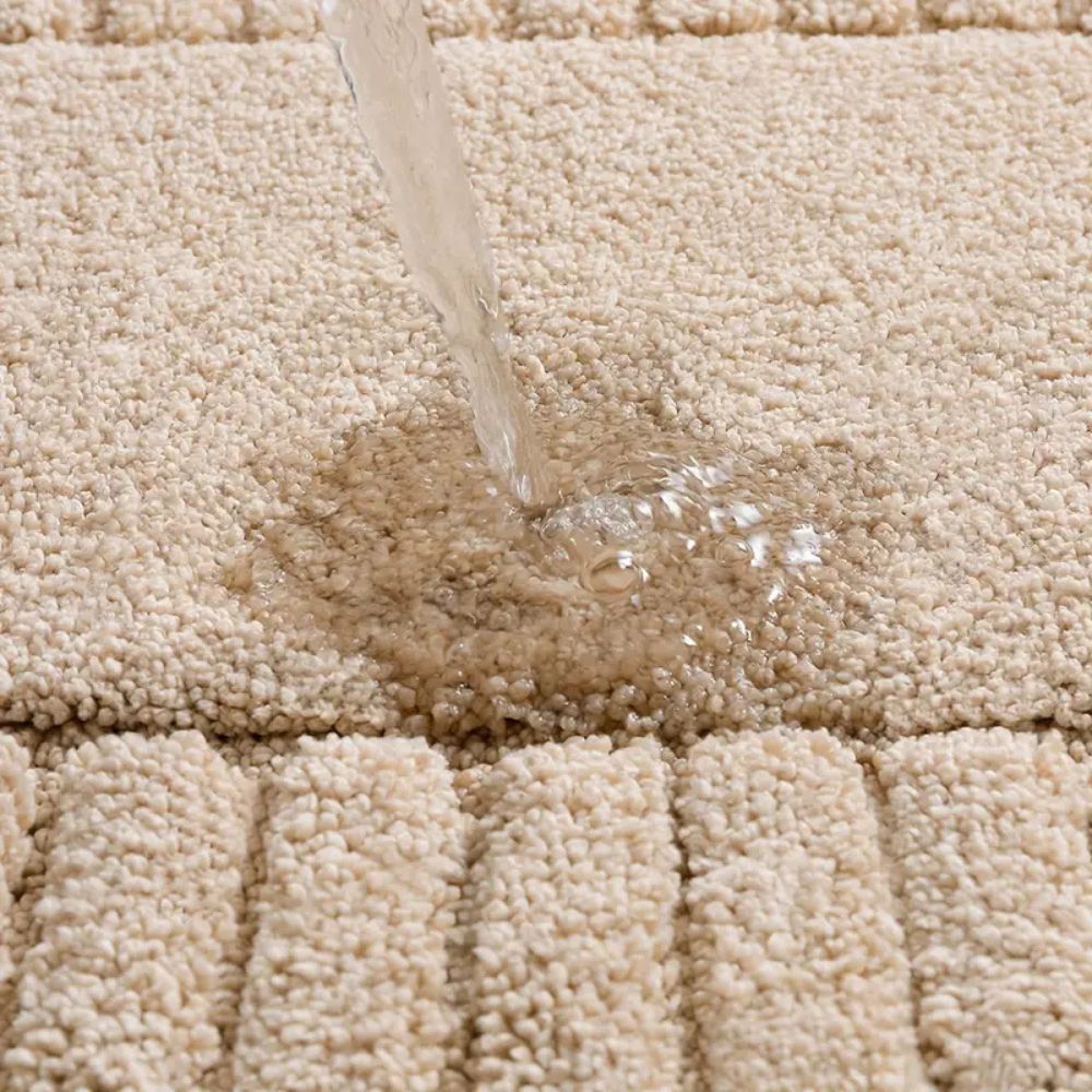 Water being poured onto a beige carpet