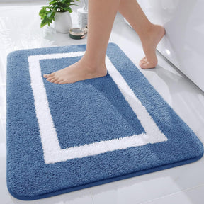 Blue bath mat with white border on a bathroom floor, person stepping onto it.