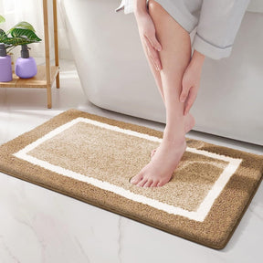 Person stepping onto a brown bath mat with a white border in a bathroom setting.