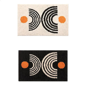 Two geometric patterned rugs with black, white, and orange design on a white background.