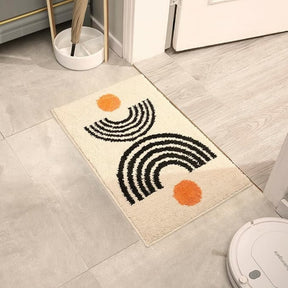 Decorative rug with black and orange patterns on a light wooden floor.
